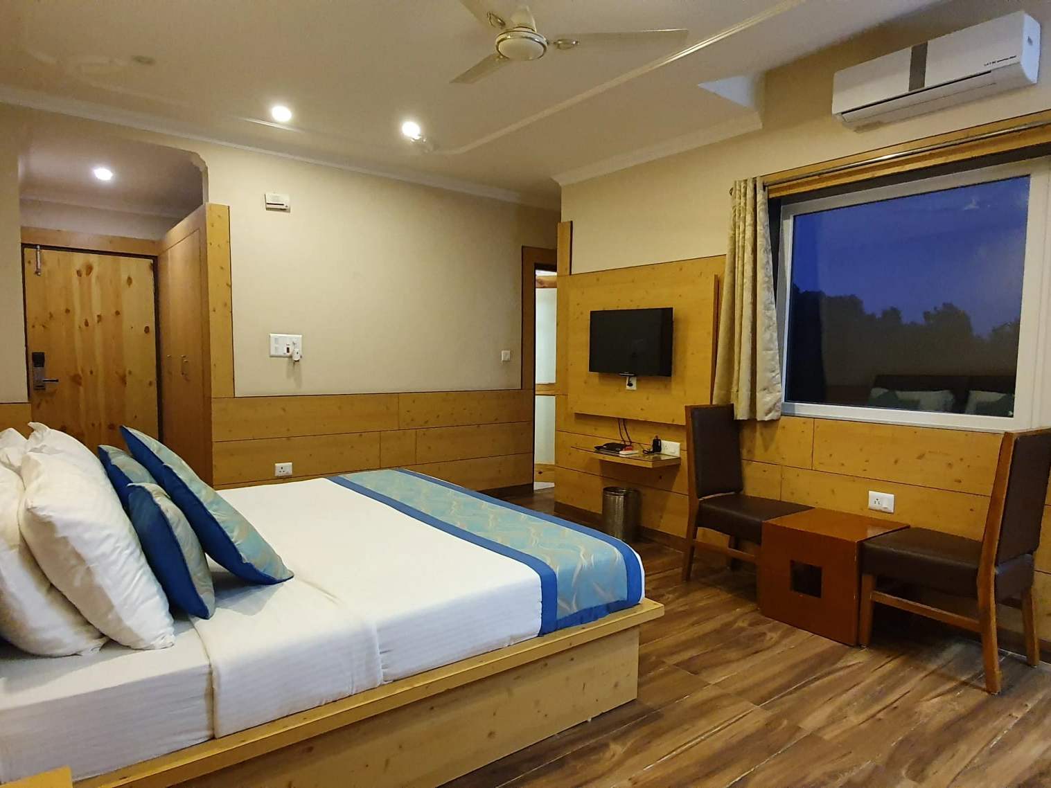 Superior room: a king-size bed, a TV and a desk in a warm, wood-trimmed room