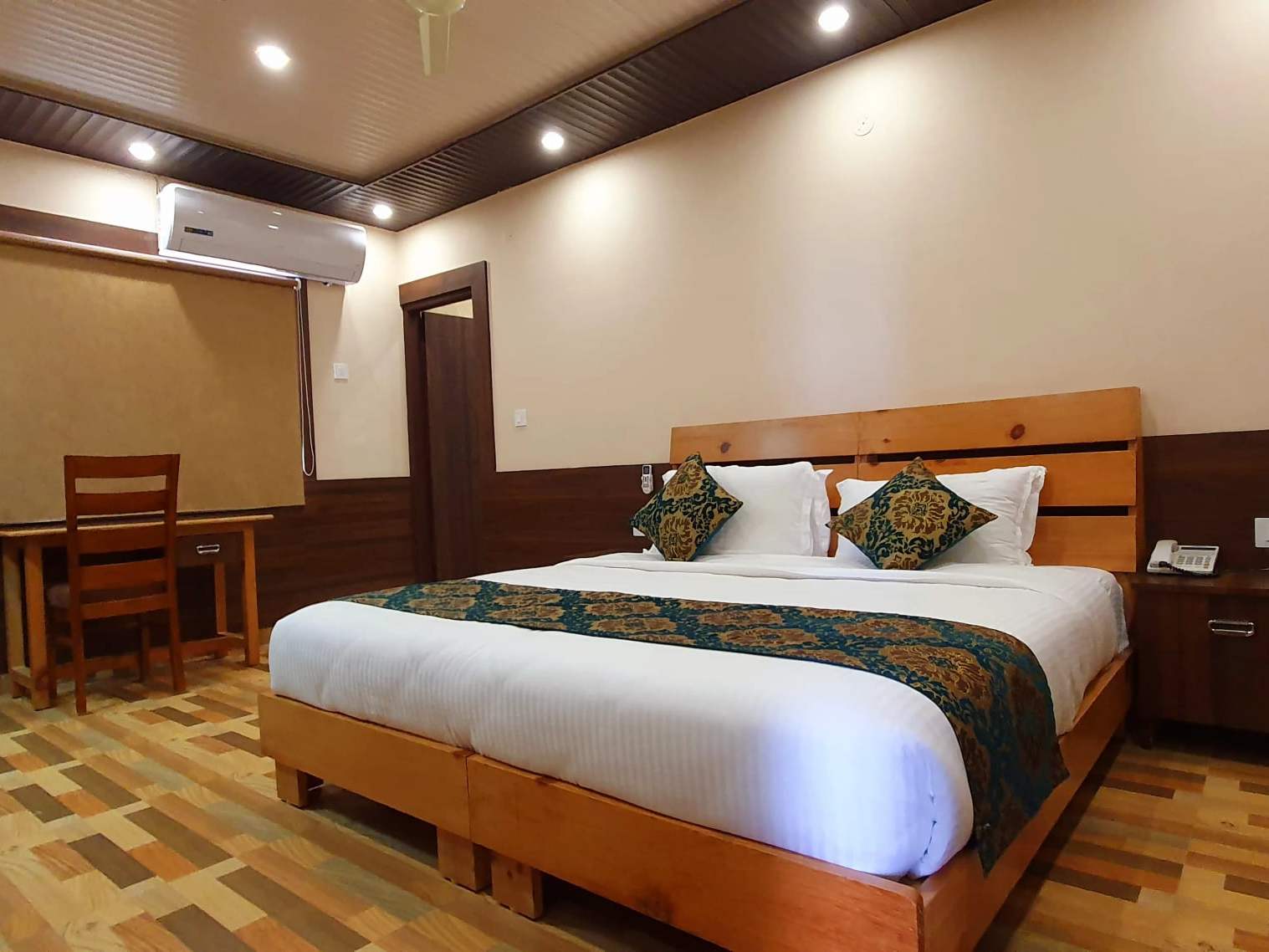 Cozy Queen room: a double bed with a patterned runner, a desk and chair under the window