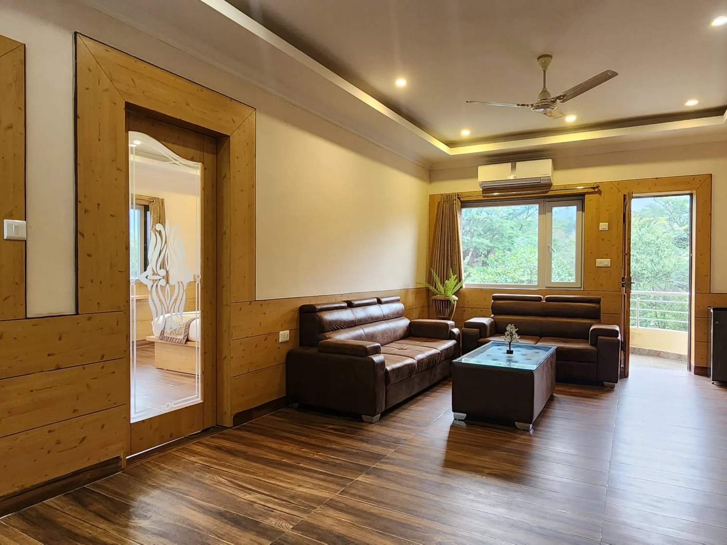 Suite living room with a leather sofa set and coffee table, opening to the bedroom