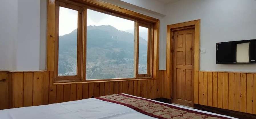 A Diwan room with a wall TV and windows onto the valley
